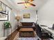 Cozy living room featuring a decorative ceiling fan, dark sofa, and a patterned rug at 709 Mandalay Ave, Clearwater Beach, FL 33767