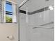 The shower is bright with white tile and a black accent line; the curtains have a nautical print at 709 Mandalay Ave, Clearwater Beach, FL 33767