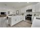 Open concept kitchen with white cabinets and island, overlooking living room at 8791 Sap Creek Pl, Tampa, FL 33614