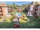 Aerial view of community showcasing lush landscaping, pool, and tiki huts at 12760 Indian Rocks Rd # 582, Largo, FL 33774