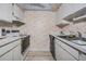 Efficient kitchen with white cabinets, essential appliances, and unique starfish wallpaper at 12760 Indian Rocks Rd # 582, Largo, FL 33774