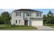 Two-story house with gray siding, red door, and two-car garage at 13024 Calcite Blue Ave, Wimauma, FL 33598