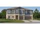 Two-story home with gray siding, brown garage doors, and landscaping at 13085 Ruby Gold Ct, Wimauma, FL 33598