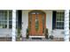 Inviting front door with glass details and decorative planters on a charming, covered porch at 13621 Mcintosh Rd, Thonotosassa, FL 33592