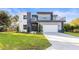 Modern two-story house with gray and white exterior, balcony, and attached garage at 6117 E 113Th Ave, Temple Terrace, FL 33617