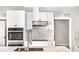 Modern kitchen with white cabinets, marble countertops, and stainless steel appliances at 6117 E 113Th Ave, Temple Terrace, FL 33617