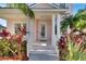 Inviting front porch with white columns, rocking chairs, and lush landscaping at 620 Mirabay Blvd, Apollo Beach, FL 33572