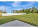 Spacious backyard with a white vinyl fence, grassy area, and concrete patio at 807 Garden Oaks Sq, Seffner, FL 33584