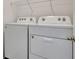 Laundry room with white washer and dryer, and wire shelving at 807 Garden Oaks Sq, Seffner, FL 33584