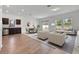 Bright living room featuring modern furniture, wood flooring, and sliding glass doors to the backyard at 807 Garden Oaks Sq, Seffner, FL 33584