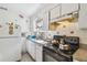 White kitchen with stove, sink, and refrigerator at 8416 N Semmes St, Tampa, FL 33604