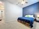 Well-lit bedroom featuring a comfortable bed and blue accent wall at 12969 Brookside Moss Dr, Riverview, FL 33579