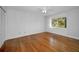 Bright bedroom showcasing gleaming hardwood floors and a sunlit window view at 1669 Fry Ct, Dunedin, FL 34698