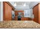 Modern kitchen featuring granite countertops and wood cabinets at 3127 W Sligh Ave # 203B, Tampa, FL 33614