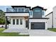 Modern two-story home with a gray and white exterior, balcony, and attached garage at 3402 W Grace St, Tampa, FL 33607