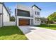 Modern two-story home with wood garage door and landscaped lawn at 3404 W Grace St, Tampa, FL 33607