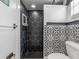 Black and white bathroom with hexagon tile shower and updated vanity at 3438 Moog Rd, Holiday, FL 34691