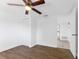 Bedroom with wood-look floors, ceiling fan, and access to another room at 3438 Moog Rd, Holiday, FL 34691