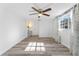 Bright bedroom with wood-look flooring, ceiling fan and access to en-suite bathroom at 3438 Moog Rd, Holiday, FL 34691