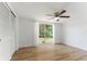 Bedroom featuring wood-look floors, large window, and ceiling fan at 3438 Moog Rd, Holiday, FL 34691