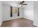 Bright bedroom with wood-look floors, ceiling fan, and window coverings at 3438 Moog Rd, Holiday, FL 34691