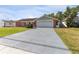Brick ranch home with a two-car garage and landscaped lawn at 3438 Moog Rd, Holiday, FL 34691