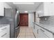 Updated kitchen features granite countertops, white cabinets, and stainless steel appliances at 3438 Moog Rd, Holiday, FL 34691