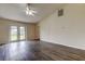 Large living area with grey vinyl plank flooring and French doors leading outside at 37500 Laurel Hammock Dr, Zephyrhills, FL 33541