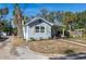 Quaint bungalow featuring a light blue exterior, yellow shutters, and a landscaped yard at 420 40Th N St, St Petersburg, FL 33713