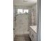 Bathroom with a shower, white vanity, and marble tile at 4312 Windmill Pointe Dr, Plant City, FL 33567