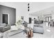 Open-concept living space featuring high ceilings, gray sofas, and a modern kitchen with bar seating at 6524 6Th N Ave, St Petersburg, FL 33710