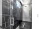 The walk-in shower features modern fixtures, hexagon tile floor, and black marble accents at 6524 6Th N Ave, St Petersburg, FL 33710
