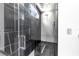 Walk-in shower boasts black marble accents, modern fixtures, and unique tile wall at 6524 6Th N Ave, St Petersburg, FL 33710