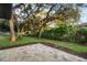 Spacious backyard featuring mature trees, lush landscaping and a stone patio at 6602 S Emerson Ave, St Petersburg, FL 33707