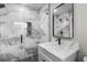 Stylish bathroom features marble tile shower with glass door, modern vanity, and black hardware fixtures at 6602 S Emerson Ave, St Petersburg, FL 33707