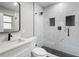 Nicely remodeled bathroom with marble tiling, rainfall shower head and black hardware at 6602 S Emerson Ave, St Petersburg, FL 33707