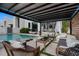 Stunning backyard with a modern pergola, poolside seating, and lush landscaping at 7602 Antilla St, Tampa, FL 33625