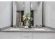 Bathroom featuring double sinks, modern fixtures, white cabinets, and a large vanity mirror at 7602 Antilla St, Tampa, FL 33625