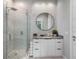 This bathroom showcases a stand-up shower, large round mirror, modern fixtures and vanity for a spa-like experience at 7602 Antilla St, Tampa, FL 33625