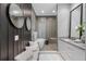 Elegant bathroom featuring a soaking tub, glass shower, and sleek vanity with dual mirrors at 7602 Antilla St, Tampa, FL 33625