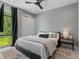 Serene bedroom with a large window, stylish black-out curtains, and a comfortable bed dressed in soft gray linens at 7602 Antilla St, Tampa, FL 33625