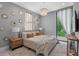 Relaxing bedroom with a decorative wall, chandelier, and large window overlooking the trees at 7602 Antilla St, Tampa, FL 33625