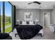 Modern bedroom with a gray accent wall and large window overlooking green space at 7602 Antilla St, Tampa, FL 33625