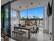An elegant covered outdoor dining area with a long wooden table, chandelier, and view of the pool and patio at 7602 Antilla St, Tampa, FL 33625
