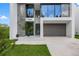 Modern home with sleek architectural lines, a two-car garage, and manicured landscaping, showcasing curb appeal at 7602 Antilla St, Tampa, FL 33625