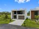 Striking modern home featuring clean lines, large windows, a spacious driveway, and beautifully landscaped front yard at 7602 Antilla St, Tampa, FL 33625