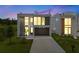 Stunning modern home showcasing a sleek design with large windows and manicured landscaping, and a spacious driveway at 7602 Antilla St, Tampa, FL 33625
