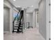 Contemporary foyer with modern staircase with metal railings and tiled floor leading to the upper level at 7602 Antilla St, Tampa, FL 33625