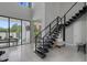 Bright, open foyer featuring a modern staircase, high ceilings, and elegant tile flooring, blending style and space at 7602 Antilla St, Tampa, FL 33625