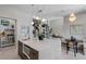 Bright kitchen showcasing a large island with seating, pendant lighting, wine storage, and a view to the living area at 7602 Antilla St, Tampa, FL 33625